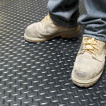 Person stood on diamond checker plate rubber matting
